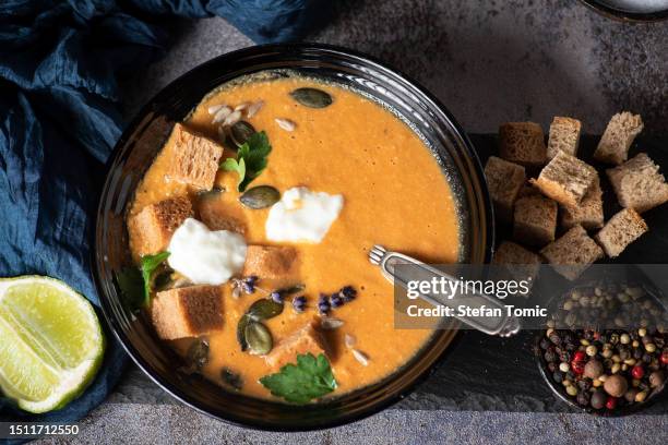pumpkin soup served in a bowl with croutons, pumpkin seeds and olive oil. - pumpkin oil stock pictures, royalty-free photos & images
