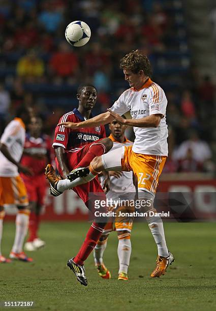 Bobby Boswell of the Houston Dynamo moves in to kick the ball away from Patrick Nyarko of the Chicago Fire during an MLS match at Toyota Park on...