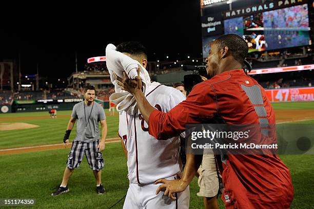 Gio Gonzalez is smeared with a shaving cream pie by Edwin Jackson of the Washington Nationals after a game against the St. Louis Cardinals at...