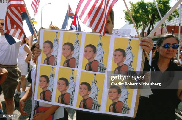 Protester holds a up a poster that shows Elian Gonzalez during a march April 29, 2000 Miami, FL. Thousands marched in protest against the Immigration...
