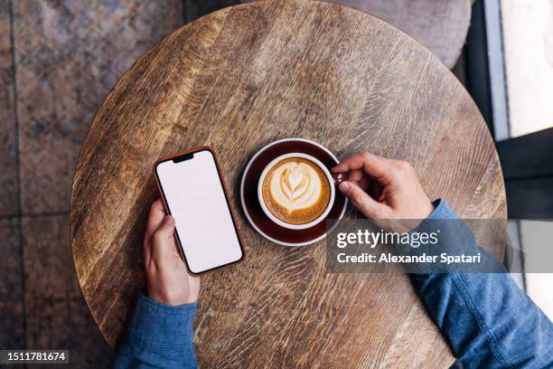 man using smartphone in a coffee shop, personal perspective directly above view - table elevated view stock pictures, royalty-free photos & images