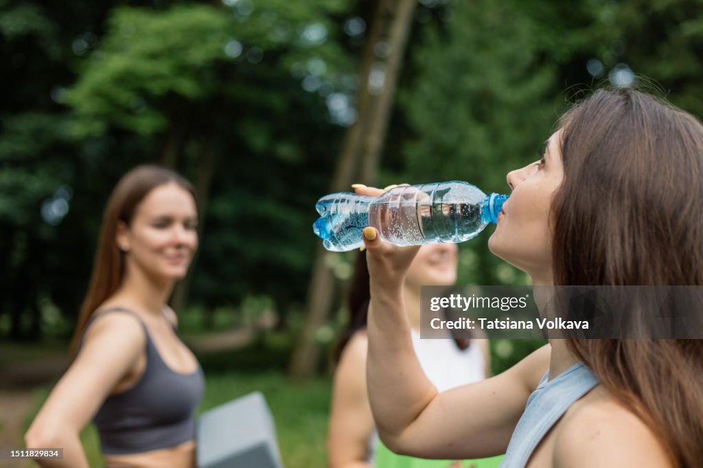 Sapping Water Lovely Female Athletes Unwind In Park Sipping Water And Enjoying ...