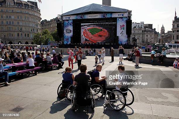Wheelchair users watch the Paralympic Games on a giant screen in Trafalgar Square on September 3, 2012 in London, England.