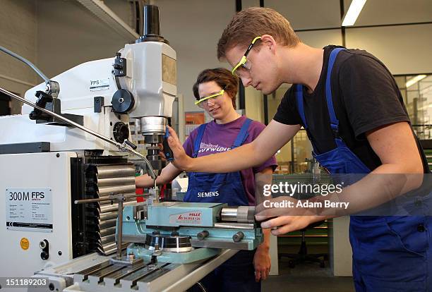 Trainees use a milling machine at a Siemens training center on September 3, 2012 in Berlin, Germany. Nearly 400 trainees began their apprenticeship...