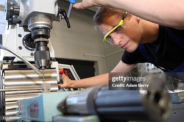 Trainee uses a milling machine at a Siemens training center on September 3, 2012 in Berlin, Germany. Nearly 400 trainees began their apprenticeship...