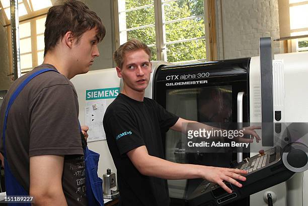 Trainees use a milling machine at a Siemens training center on September 3, 2012 in Berlin, Germany. Nearly 400 trainees began their apprenticeship...