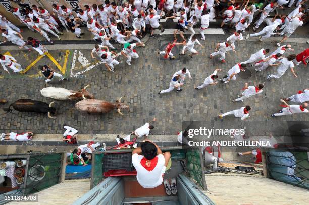 Resident watch from their balcony as participants run with bulls during the first "encierro" of the San Fermin festival in Pamplona, northern Spain,...