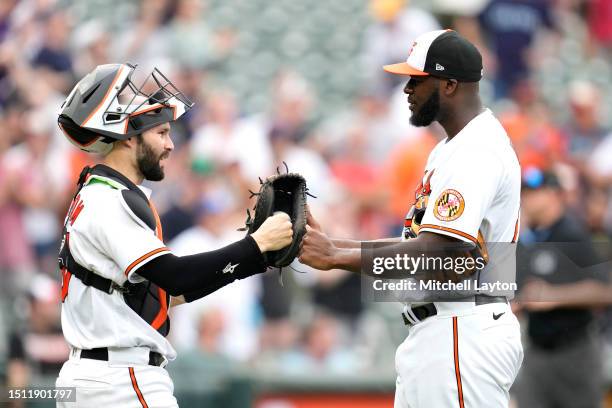 Anthony Bemboom and Felix Bautista of the Baltimore Orioles celebrate a win after looks to third to second base during a baseball game against the...