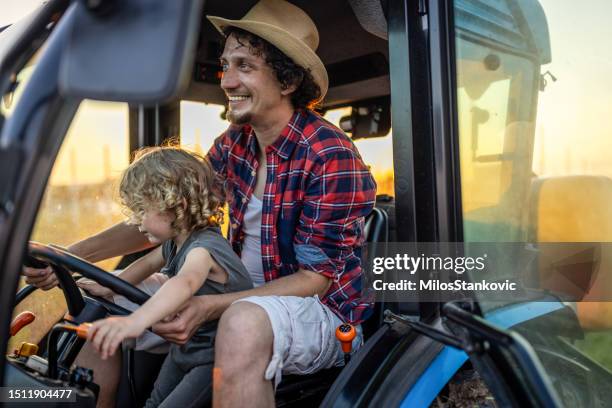 farmer dad with his boy in tractor at farm - tractor driver stock pictures, royalty-free photos & images