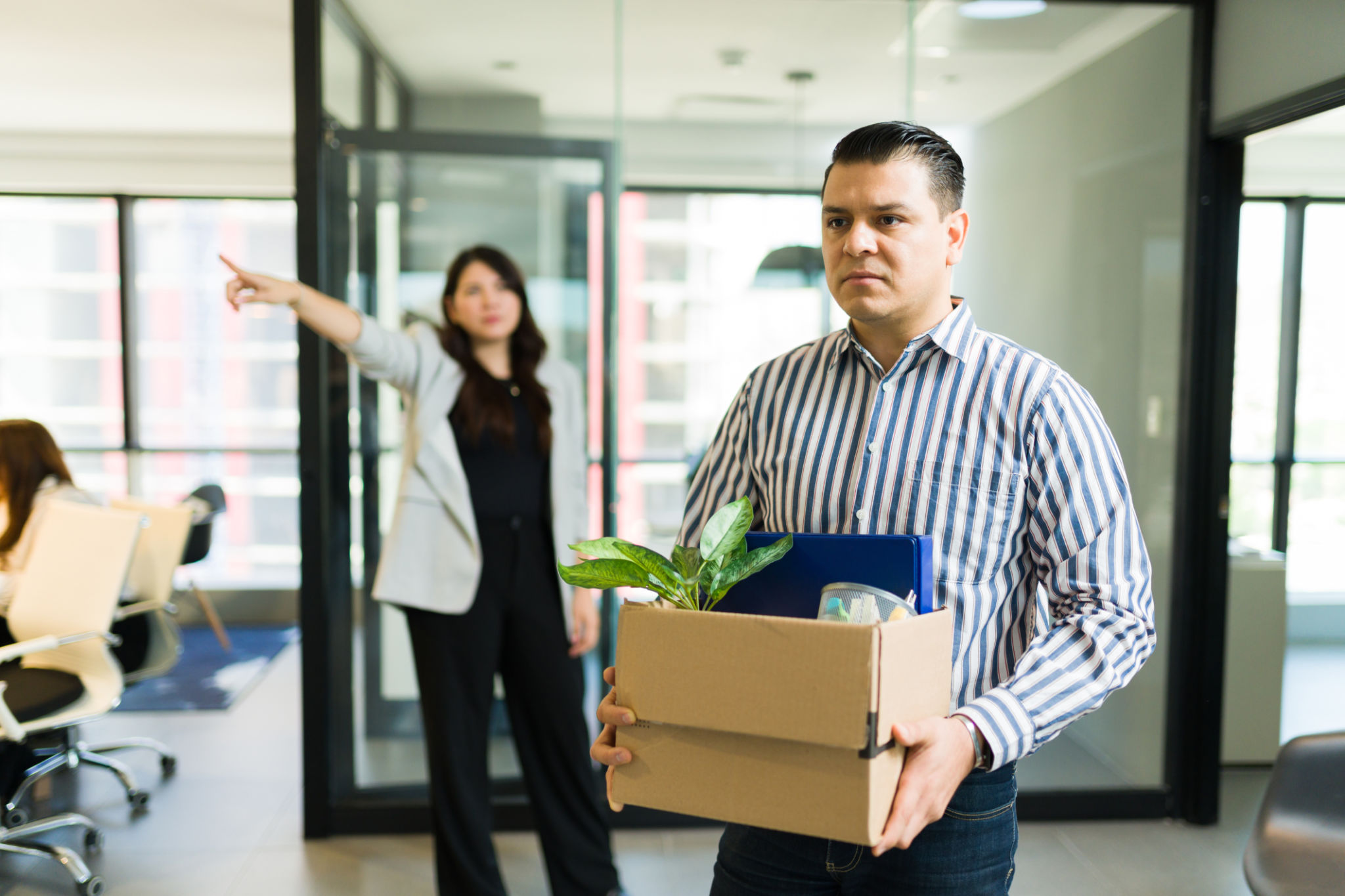 Sad mid adult male employee being dismissed by angry boss in office Sad mid adult male employee being dismissed by angry boss in office