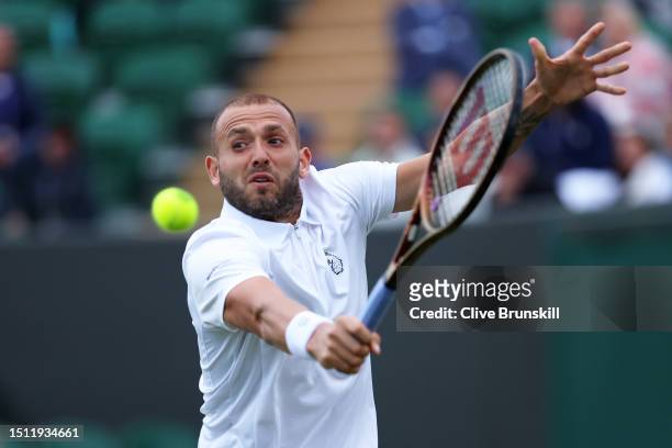 Daniel Evans of Great Britain plays a backhand against Quentin Halys of France in the Men's Singles first round match on day one of The Championships...