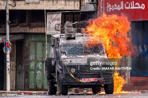 Molotov cocktail explodes on an Israeli armoured vehicle in clashes with Palestinians during an Israeli military raid in the old city of Nablus in...