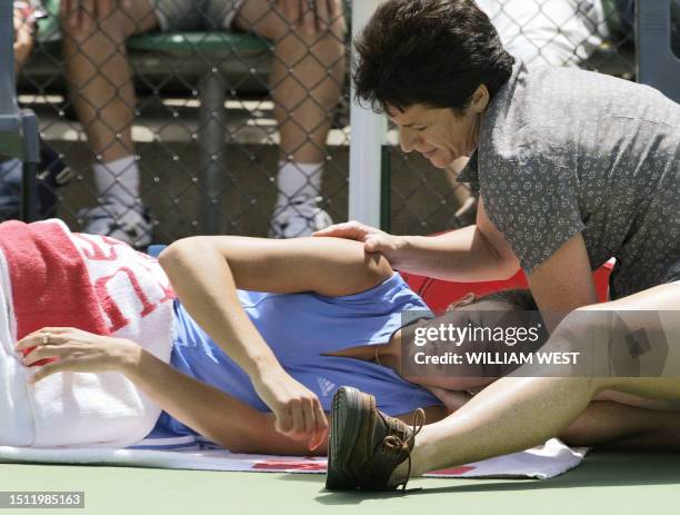 Marta Marrero of Spain receives treatment from the courtside trainer during a injury time-out in her match against Patty Schnyder of Switzerland in...