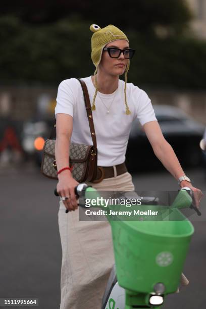 July 02: Guest is seen wearing frog inspired green crocheted hat, white t-shirt, big brown belt, Gucci Horsebit bag, and a beige long skirt outside...