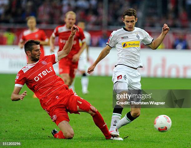 Branimir Hrgota of Moenchengladbach fouls Stelios Malezas of Duesseldorf during the Bundesliga match between Fortuna Duesseldorf and Borussia...