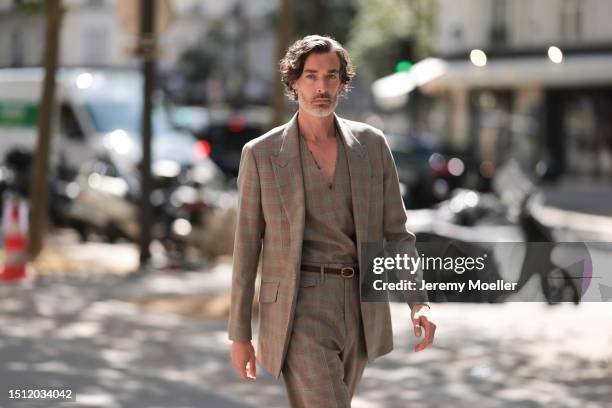 June 23: A Fashion Week guest is seen wearing a matching wool two-piece suit with a mint and grey check pattern consisting of a long coat, a pullover...