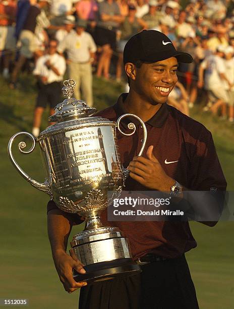 Tiger Woods smiles while holding the Wanamaker Trophy August 20, 2000 after winning the PGA Championship over Bob May in a three-hole playoff at the...