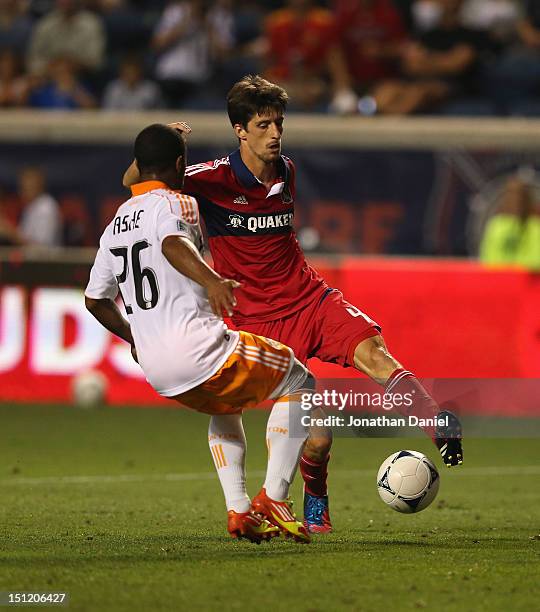 Alvaro Fernandez of the Chicago Fire controls the ball under pressure from Corey Ashe of the Houston Dynamo during an MLS match at Toyota Park on...