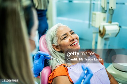 Mature woman having teeth examined by a dentist at her office