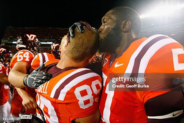 Linebacker Bruce Taylor of the Virginia Tech Hokies congratulates kicker Cody Journell of the Hokies after Journell kicked the game winning field...