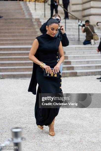 Amina Muaddi is seen wearing black dress with slit outside Schiaparelli during the Haute Couture Fall/Winter 2023/2024 as part of Paris Fashion Week...