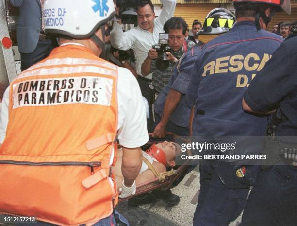 Bomberos del Districto Federal evacuan en una camilla uno de los cuatro obreros que fueron heridos sin gravedad mientras cumplian con labores de...