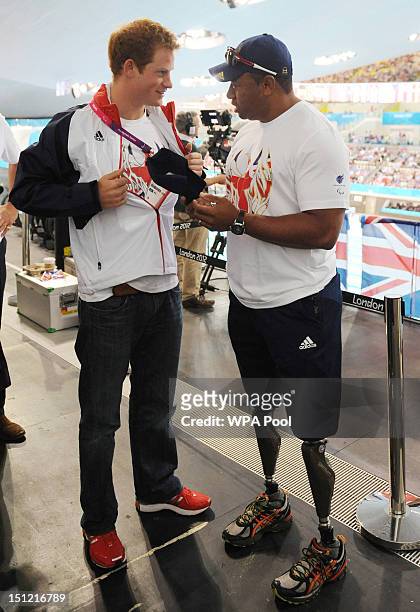 Prince Harry meets former soldier and Paralympic athlete Derek Derenalagi during his visit to the Aquatics Centre where he watched the swimming heats...