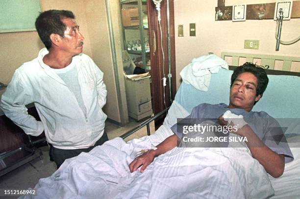 El campesino Romeo Nunez de 25 anos es observado por su padre cuando yace herido en una cama del hospital central de Comitan, Chiapas 23 de Julio....