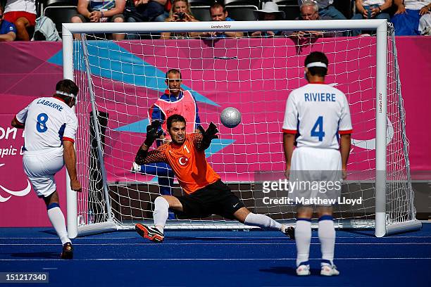 David Labarre of France scores a penalty against Ali Hidir Kurt of Turkey as Gael Riviere of France watches in their men's Team Football 5-a-side -...