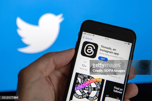 In this photo illustration, Threads logo by Meta seen displayed on a smartphone and a Twitter logo in the background. Threads is the new social...