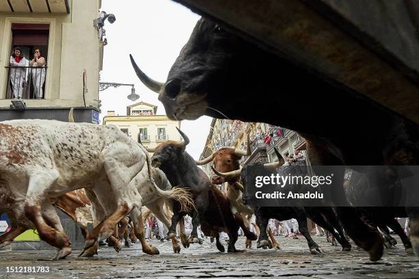 People take part in the traditional 'encierro' of the San Fermin Festival in Pamplona, Spain on July 07, 2023. The bull-running fiesta is held...