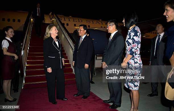 Secretary of State Hillary Clinton is greeted by US Ambassador to China Gary Locke and Director General for North American and Oceanian Affairs Xie...