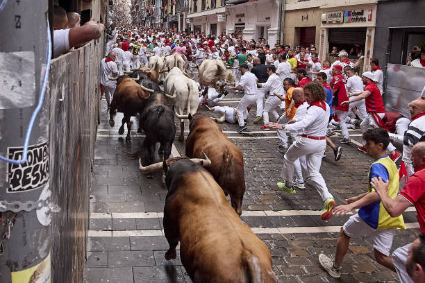 People take part in the traditional 'encierro' of the San Fermin Festival in Pamplona, Spain on July 07, 2023. The bull-running fiesta is held...