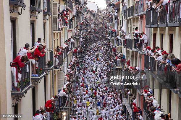 People take part in the traditional 'encierro' of the San Fermin Festival in Pamplona, Spain on July 07, 2023. The bull-running fiesta is held...