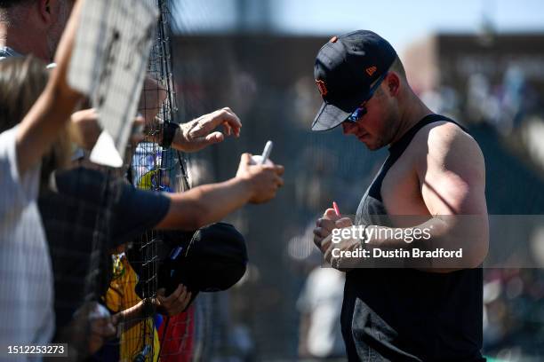 Spencer Torkelson of the Detroit Tigers signs autographs for fans in the stands after a game against the Colorado Rockies at Coors Field on July 2,...