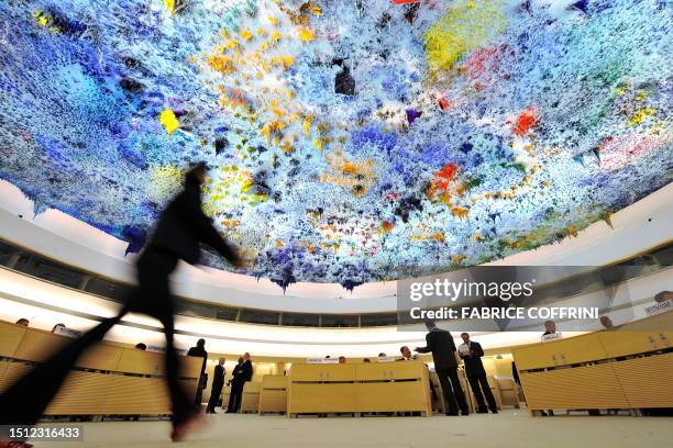 Delegate walks beneath the ceiling painted by Spanish artist Miquel Barcelo on June 2, 2009 before the opening of a new UN Human Rights Council...