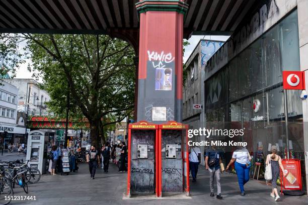 Street scene on Brixton Road with two vandalised telephone boxes in the diverse community of Brixton on 22nd June 2023 in London, United Kingdom....