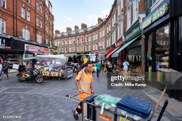 Street cleaner in the vibrant Brixton Market on Electric Avenue in the diverse community of Brixton on 22nd June 2023 in London, United Kingdom....