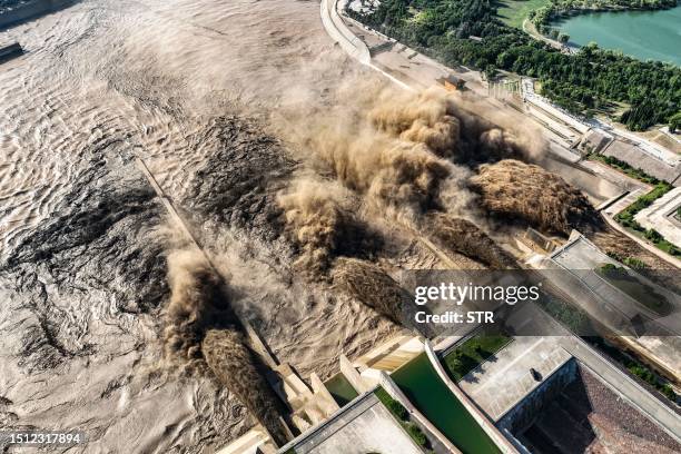 This aerial photo taken on July 7, 2021 shows water and sand being released from the Xiaolangdi Reservoir Dam in Jiyuan, in China's central Henan...