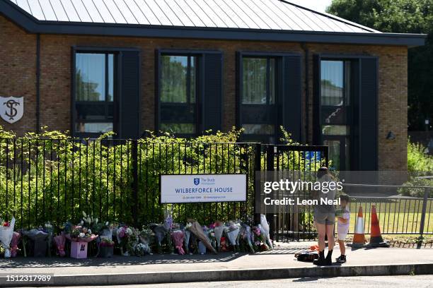 People arrive to lay flowers in tribute to the victims of a car crash outside The Study Preparatory School on Camp Road on July 7, 2023 in Wimbledon,...