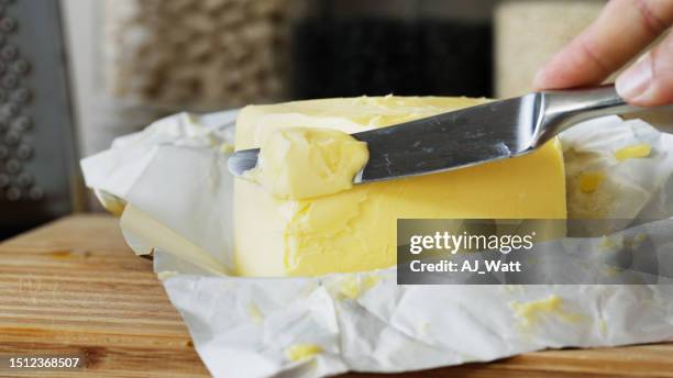 mujer cortando a mano mantequilla fresca con un cuchillo de mesa - butter making fotografías e imágenes de stock