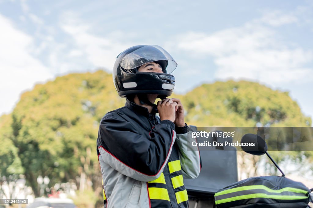 Delivery man removing helmet.