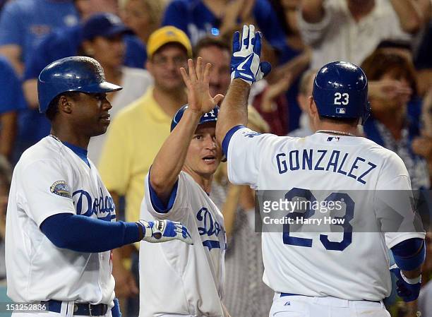 Ellis of the Los Angeles Dodgers celebrates his run from an Adrian Gonzalez sacrifice fly with Hanley Ramirez for a 3-1 lead over the San Diego...