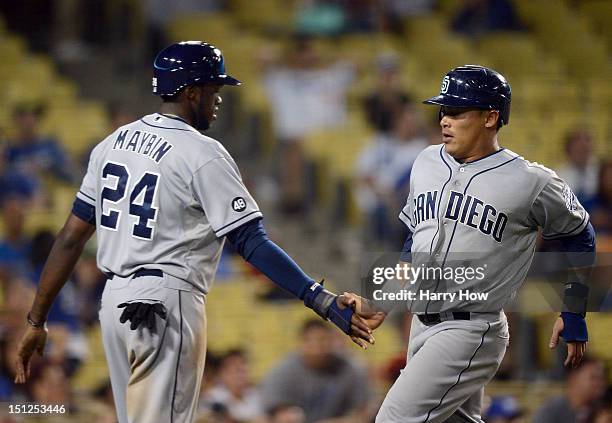 Everth Cabrera and Cameron Maybin of the San Diego Padres celebrate their runs off a Logan Forsythe single to take a 5-3 lead during the 11th inning...