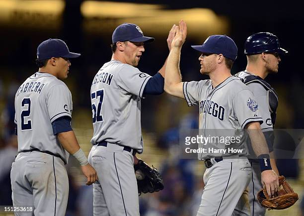 Logan Forsythe of the San Diego Padres celebrates a 6-3 win over the Los Angeles Dodgers with Everth Cabrera, Luke Gregerson and Yasmani Grandal at...