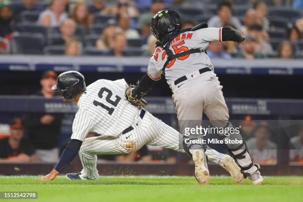 Isiah Kiner-Falefa of the New York Yankees is tagged out by Adley Rutschman of the Baltimore Orioles trying to score on a ground ball to the pitcher...