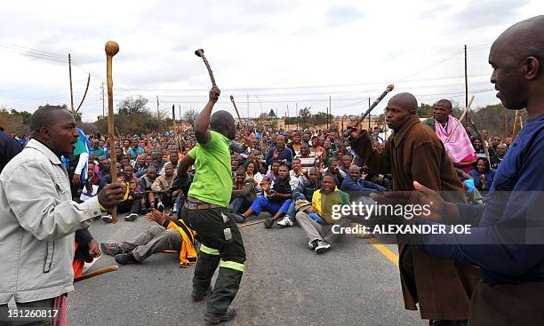 Thousands of striking workers singing and carrying sticks march on a South African mine in Marikana on Sepember 5 as police were accused of shooting...