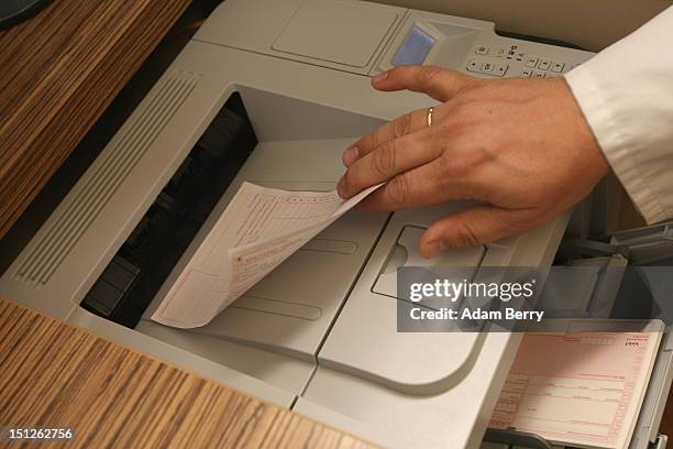 Doctor retrieves a prescription from a computer printer on September 5, 2012 in Berlin, Germany. Doctors in the country are demanding higher payments...