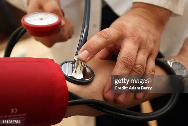 Doctor checks a patient's blood pressure on September 5, 2012 in Berlin, Germany. Doctors in the country are demanding higher payments from health...