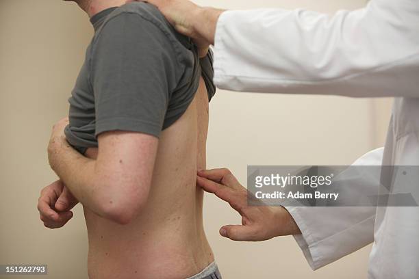 Doctor checks a patient's spine on September 5, 2012 in Berlin, Germany. Doctors in the country are demanding higher payments from health insurance...